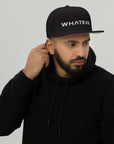 Unisex Unbothered snapback hat in black with embroidered WHATEVR text, front view
