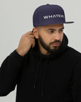 Unisex Unbothered snapback hat in blue with embroidered WHATEVR text, front view