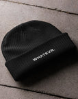 Unisex WHATEVR beanie in black with embroidered detailing, front view