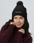 Unisex Signature pom pom knit beanie in black with embroidered WHATEVR text, front view