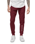 Men's essential slim fit sweatpants in maroon, front view.