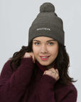 Unisex Signature pom pom knit beanie in gray with embroidered WHATEVR text, front view