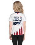 Person wearing a white sports jersey with 'This is Home' text and American flag design on a white background
