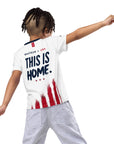 Person wearing a white t-shirt with 'This is Home' text and an American flag design on a white background