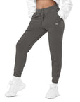 Women's essential relaxed sweatpants in grey with embroidered detailing, front view.
