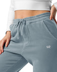 Women's essential relaxed sweatpants in blue with embroidered detailing, front view.
