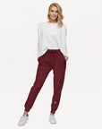 Women's essential slim fit sweatpants in maroon, front view.