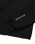 Women's cropped hoodie in black with "WHATEVR" text, side view.